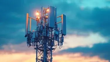 Telecommunications tower with antennas and signal equipment against a dramatic sky