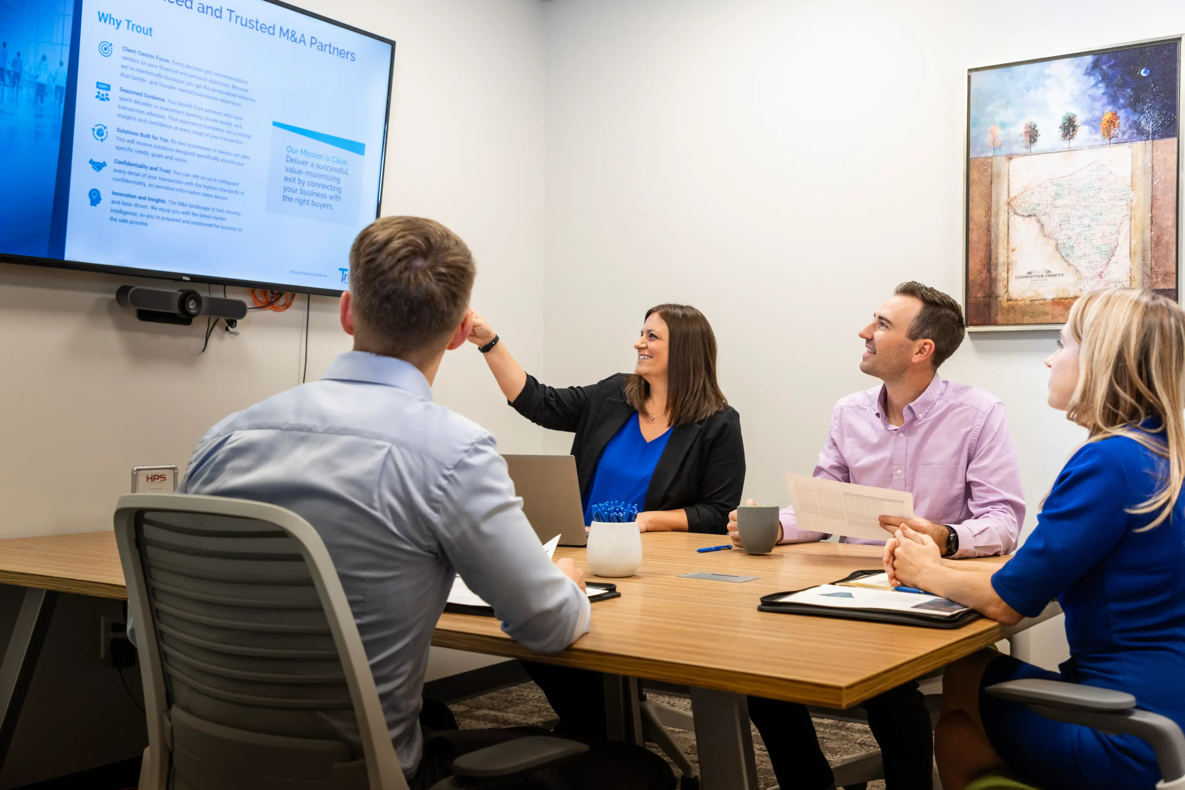 professionals reviewing an M&A presentation in a conference room